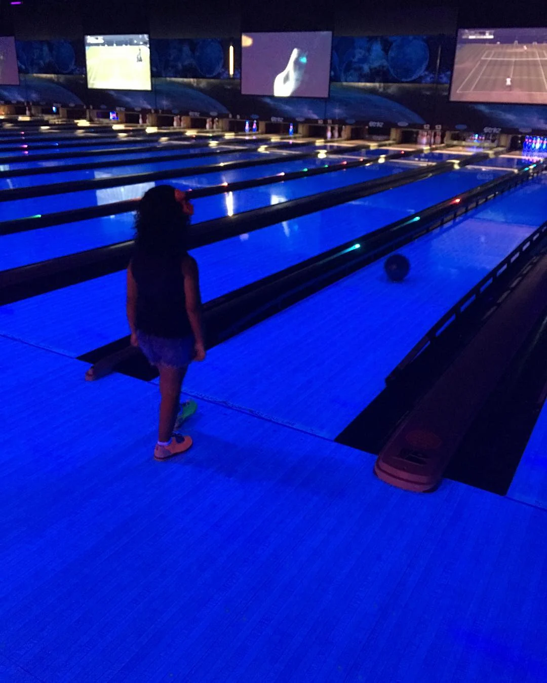 a child bowling at a glow in the dark bowling alley