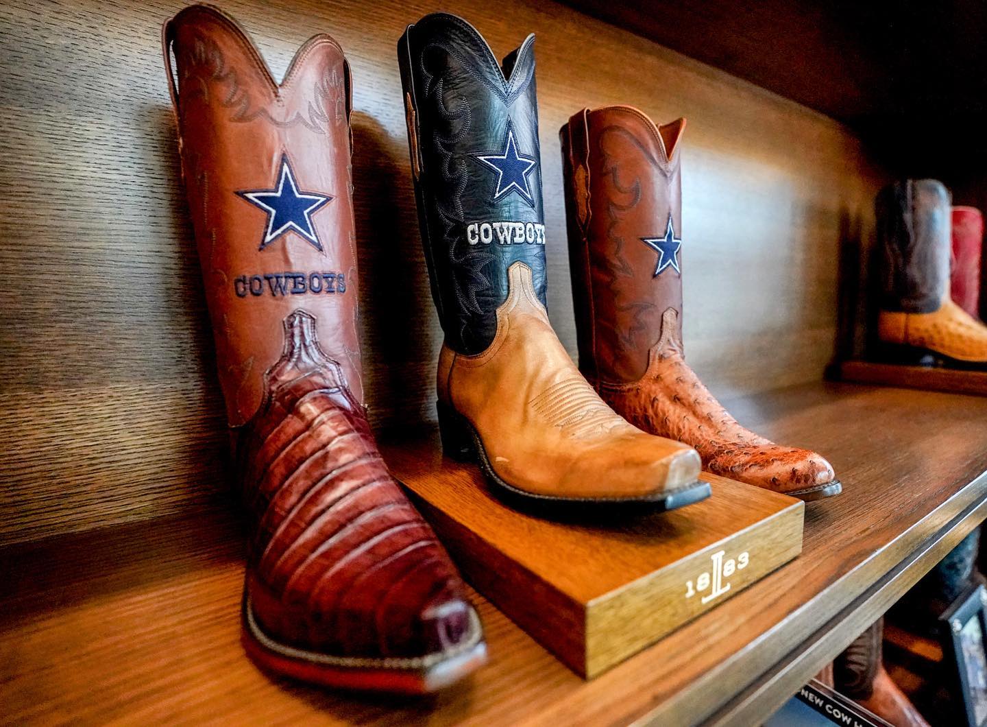 a display of cowboy boots with the Dallas Cowboy logo on them